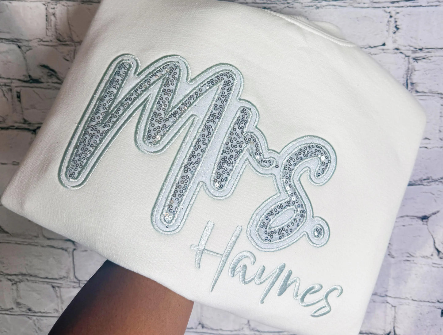 White crewneck with silver sequin Mrs. appliqué and personalized Haynes embroidery